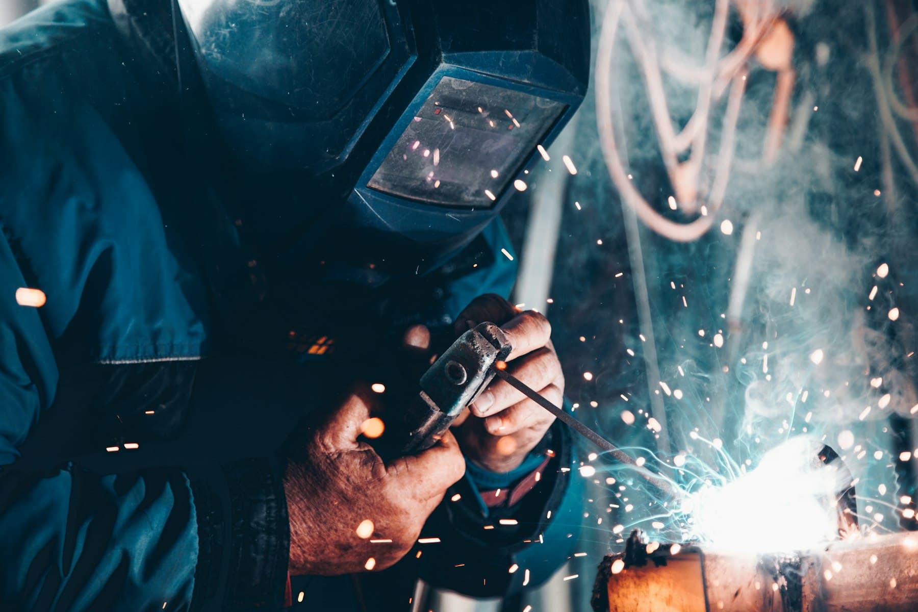 Welder working with a welding machine in a workshop
